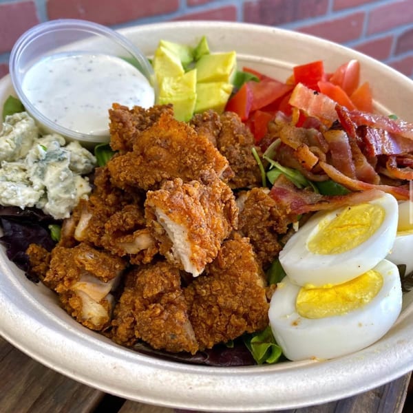 Franks Burgers' crispy chicken salad with bacon, avocado, tomatoes, blue cheese, hard-boiled eggs, and ranch.
